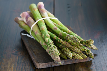 1 lb/0.5 kg of fresh organic asparagus on a wooden table. High resolution