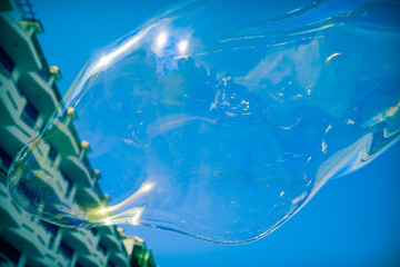 Bright soap bubble against the background of the building. Soap bubble mirror in modern town - Image