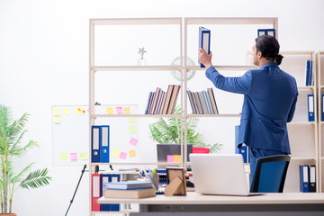 Young handsome employee in the office 