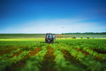 Verduisterende rolgordijnen Tractor Boer in tractor die land voorbereidt met cultivator in het voorjaar