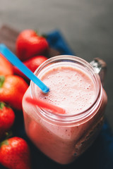 Smoothie with strawberry and banana in the jar at dark background
