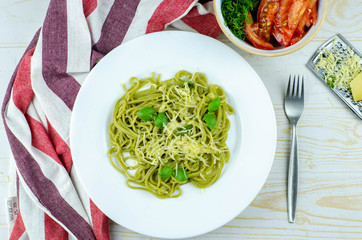 green spinach spaghetti with basil and cheese