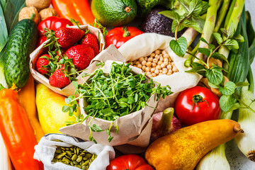 Balanced vegetarian food background. Vegetables, fruits, berries, nuts, sprouts, seeds, chickpeas on a white background.