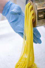 Process of production of pasta. Manufacture of fresh spaghetti with pasta machine