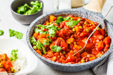 Fototapeta na wymiar Vegan bean stew with tomatoes in a pan over white background.
