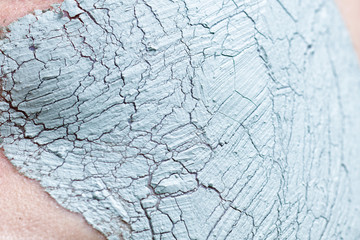 Closeup view of cracked texture clay facial mask. Skincare, beauty, cosmetology concept.