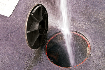 sewer line drainage  by utilities workers with hose with pressurized water of service truck