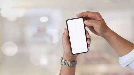 Close up man hands using mobile smartphone over blurred bokeh background