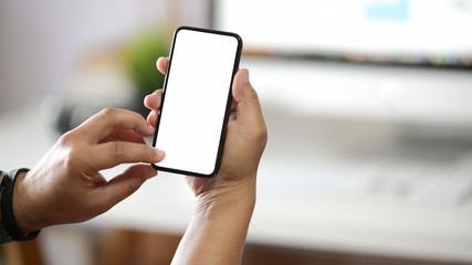 Businessman holding white blank screen  smartphone in workplace