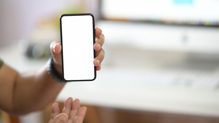 Close-up male hand holding mobile phone with blank screen