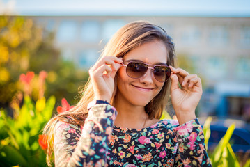 Girl in the spring. Portrait of a beautiful smiling girl outdoor. Girl with long hair in the summer. Smiling girl is traveling.  Student on the background of school