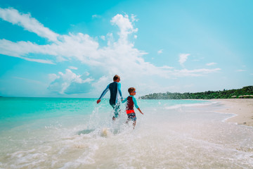 father and son play with water run on beach