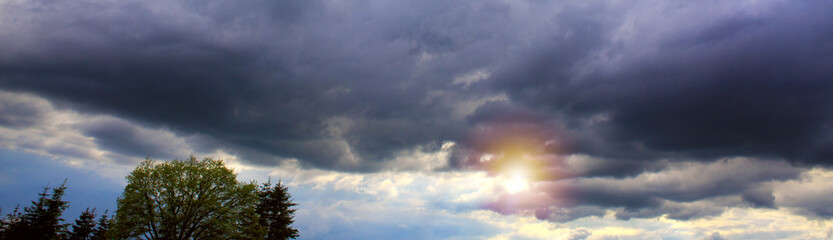 Beautiful sunset sky above gray clouds with dramatic light.