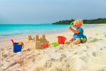 Fototapeta na wymiar cute little girl playing with sand on beach