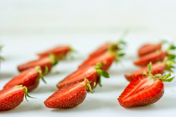 Cut along strawberries on a light background.