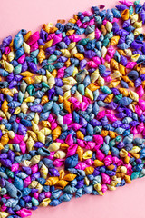 Multicolored seashells background on pink, top view, copy space. Summer concept, hello summer greeting card