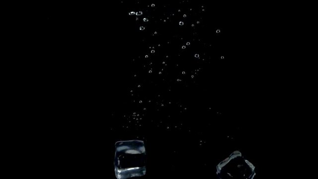 ice cubes drop in water isolated black background