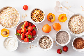 variaty of raw cereals, fruits and nuts for breakfast. Oatmeal flakes and steel cut, barley, walnut, chia, apricot, strawberry. Healthy ingredients