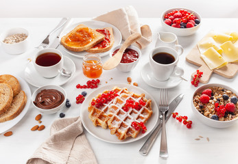 Fototapeta na wymiar breakfast with granola berry nuts, waffle, toast, jam, chocolate spread and coffee