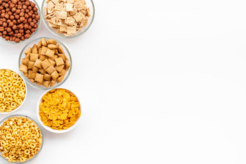 Various cereals in bowls on white background top view copyspace
