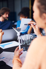 Woman's hand holding a model of wind turbine