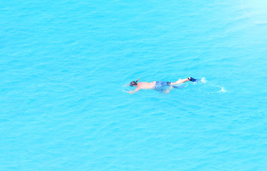 Man swims in the sea with a mask and snorkel