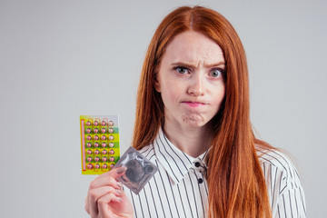 picture of young redhead be lost in thought businesswoman in striped shirt with one pack of pills thinking white background studio