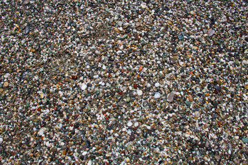 Colorful small rounded wet pebbles on a shingle beach