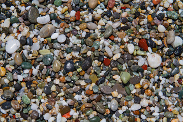 Colorful small rounded wet pebbles on a shingle beach