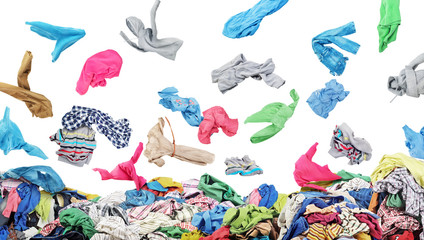 Separate clothing falling at the big pile of clothes on a white background