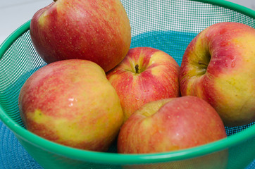 Ripe apples in a green basket. Fruits. Summer