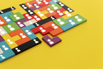 image of tangram puzzle blocks with people icons over wooden table ,human resources and management...
