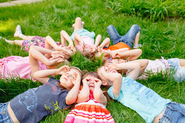 Fototapeta premium a group of children playing and running in the park on a green gozon.