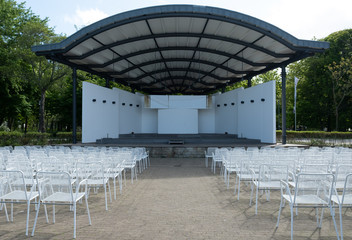 Eine leere Open-Air-Halle mit weißen Stühlen