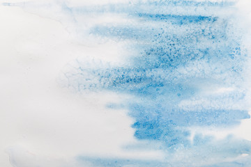 blue watercolor paint spill on white textured background with copy space