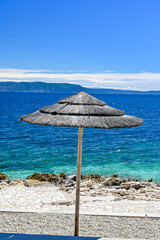 empty stone beach with sunshades in Rabac Croatia