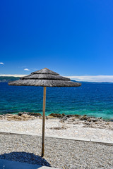 empty stone beach with sunshades in Rabac Croatia