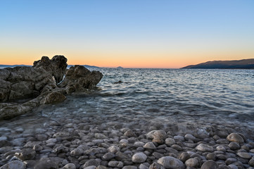 Fototapeta na wymiar sunrise over a stone beach in Rabac Croatia