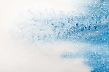 close up view of blue watercolor paint spill with dots on white background