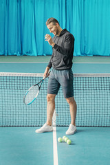high athlete on the tennis court. young guy holding a rocket and playing tennis.
