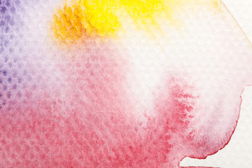 Fototapeta premium top view of yellow, purple and red watercolor pale paint spills on white background