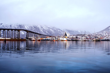 Obraz premium Cloudy day in famous north town Tromso, Norway. View of the fjord with houses
