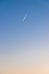 夕焼けの中の飛行機雲