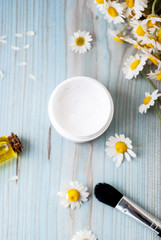 Obraz na płótnie Canvas homemade herbal cosmetics with camomile, essential oils, facial cream