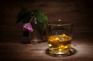 Still life with a glass of whisky on wooden background