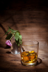 Still life with a glass of whisky on wooden background