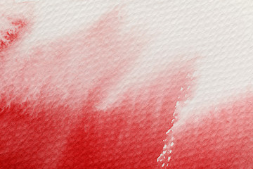 close up view of red paint spill on white textured background