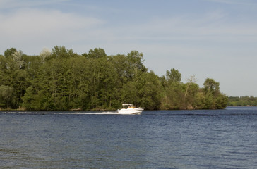 Obraz na płótnie Canvas a yacht, a boat carries people along a wide river