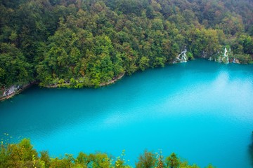 Top view of a large blue lake in Plitvice lakes national Park, Croatia. Beautiful landscape: clean blue water, forest, waterfalls. Amazing nature landscape, outdoor travel background.