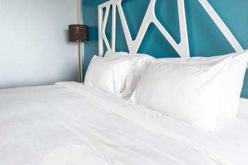 Close up white bedding sheets and pillow in modern bedroom.